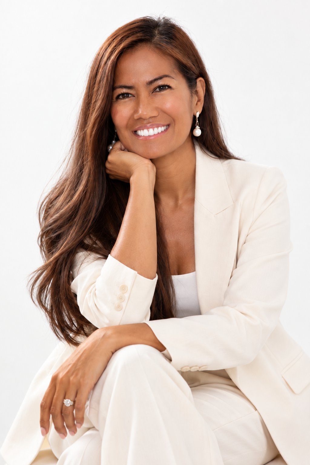 Vanessa seated in a white suit