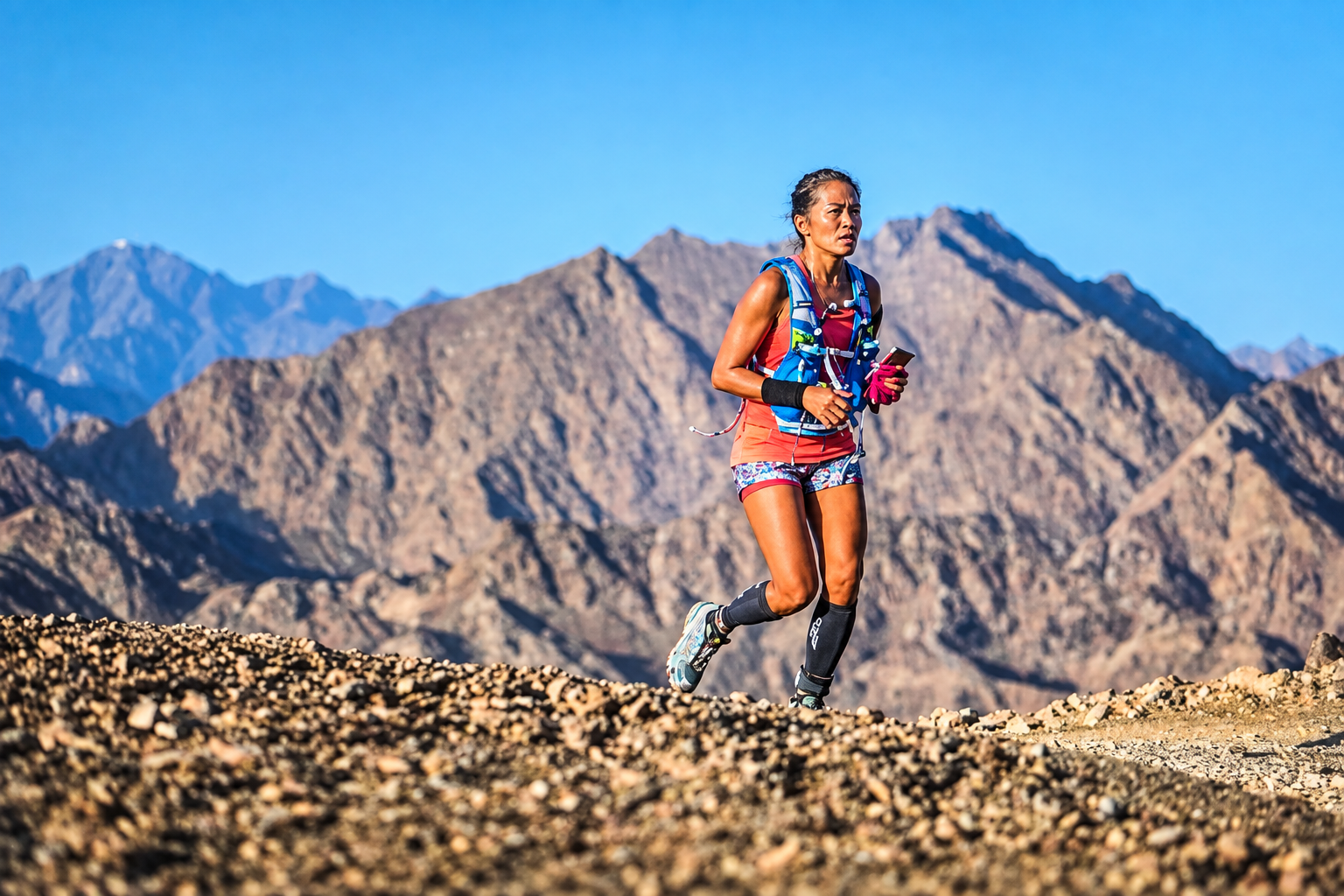 Vanessa trail running through mountain terrain